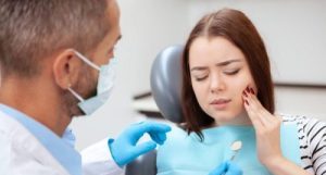 Women holding her mouth in pain.