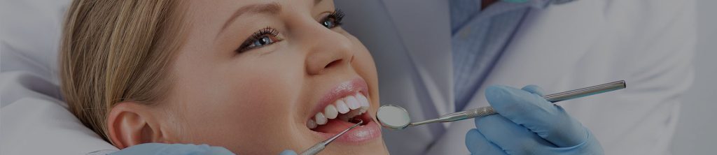 Dentist looking in patient's mouth.